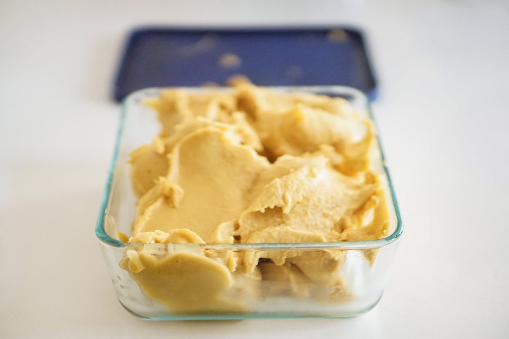 Creamy homemade ice cream in a clear glass container, perfect for dessert lovers.